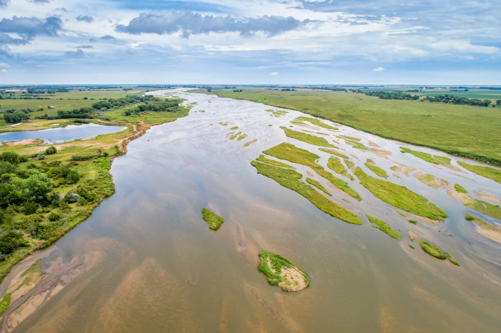Aerial view of a winding river surrounded by green fields near Kearney, Nebraska.